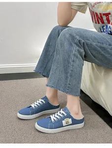 Mules de mezclilla azul para mujer con cordones blancos y detalles de bordes deshilachados