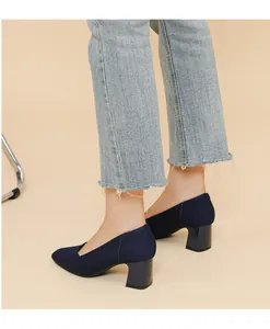 Close-up side view detail of navy blue knitted block heel pumps with vertical stripes