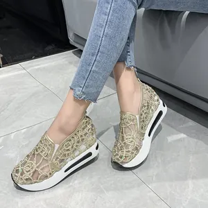 Side view of gold embroidered mesh wedge shoes on model wearing jeans