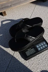 Chanclas negras con plataforma pesadas en una báscula que marca un peso de 271,3 g