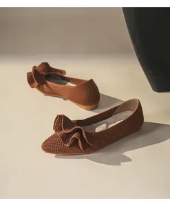 Detaillierte Makroansicht terrakottafarbener Strickschuhe mit eleganten Netz-Rüschen-Akzenten