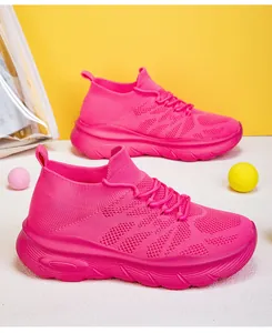 Close-up of vibrant pink fly-knit sock sneakers with thick wavy soles in detail view