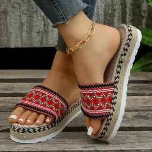 Close-up of ethnic style women's platform slippers with woven red straps and jute rope sole
