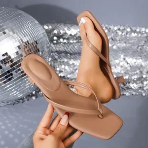 Detail view of stylish tan square-toe flip-flop sandals featuring low kitten heels