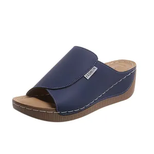Seitenansicht einer blauen Keilsandalette mit Peep-Toe und weißen Kontrastnähten.