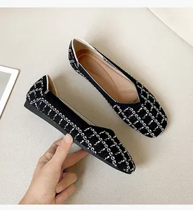 Close-up of black and white woven flat shoe showing square toe detail and texture