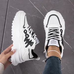 Close-up detail of chunky white fishbone sneakers featuring breathable mesh panels.