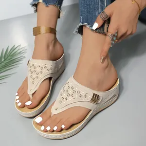 Detailansicht beige Keilabsatz-Zehentrenner mit aufwendigen lasergeschnittenen Blumenmustern