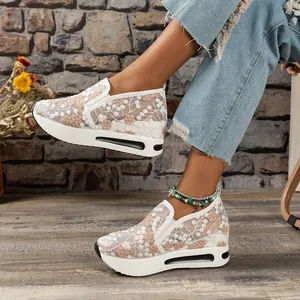 Detailed view of floral lace mesh platform sneakers on a rustic background.
