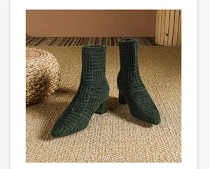 Detailweergave van de donkergroene pluizige gebreide textuur op de elastische sock boots