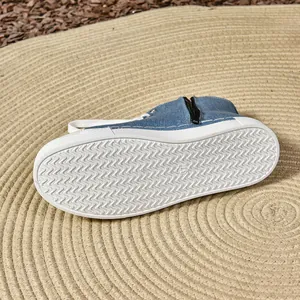 Detailopname van de blauwe canvas sneakers met golvende zool en een handige zijrits