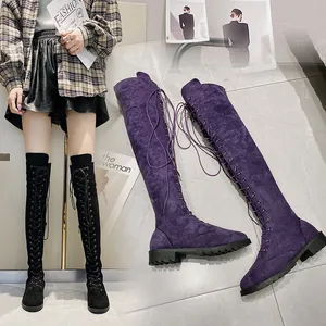 Dettaglio di stivali sopra il ginocchio in camoscio viola e nero con lacci alla moda