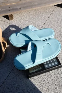 Primer plano detallado de chanclas de plataforma azul claro en una báscula para pesar el calzado