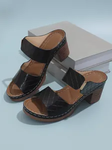 Vue détaillée des sandales à plateforme matelassées noires avec des talons blocs marrons