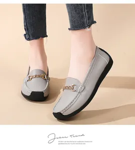 Detailed view of comfortable grey leather loafers featuring a stylish gold chain buckle