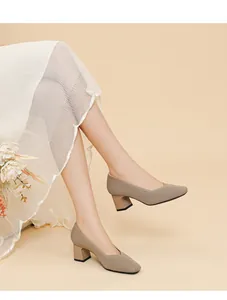 Elegant beige ribbed block heel pumps with square toe and V-neckline on model feet