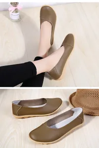 Detailed view of brown leather loafers with soft rubber sole on a wooden floor.