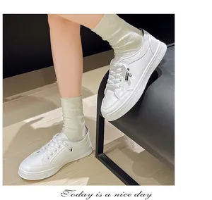 Dettaglio delle eleganti sneaker bianche da donna abbinate a comodi calzini bianchi
