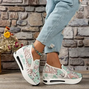 Detail of women's breathable mesh platform shoes with green floral lace pattern.