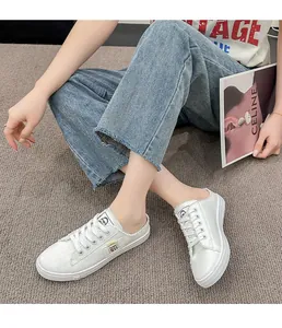 Zapatillas casuales de lona blanca para mujer con jeans en un entorno cómodo y relajado