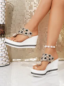 Detail view of women's rhinestone wedge thong sandals with pearl embellishments