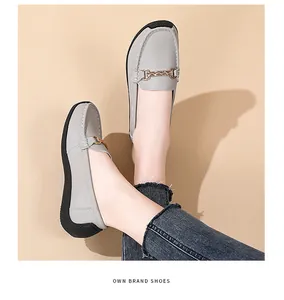 Close-up detail of grey leather loafers with elegant metal buckle decoration