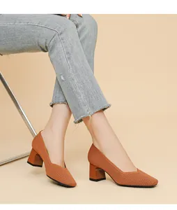 Close-up of orange knit block heel pumps with V-neck and square toe design.