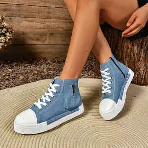 Detail van dames denim high-top sneakers met dikke zolen en een ritsvak aan de zijkant.