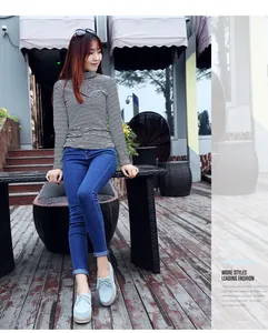 Vista detallada de mocasines con plataforma azul claro con borlas usados por modelo