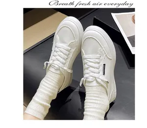 Dettaglio ravvicinato di sneaker retrò bianche stringate con comoda suola piatta