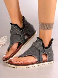 Detail shot of women's denim flip-flop sandals with studs and rear zipper closure