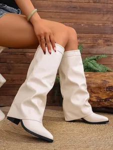 Detail view of stylish white pleated pants boots with chunky heels and pointed toes