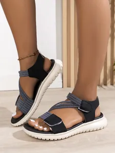 Close-up of women's black velcro sandals with woven straps and chunky white soles