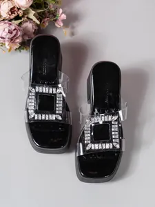 Detailed view of the sparkling rhinestone square buckle on transparent PVC strap