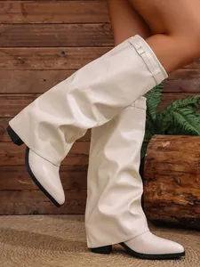 Close-up of cream slouchy knee-high boots with pointed toe and block heel.
