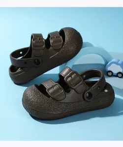 Close-up view of brown closed-toe children's sandals with decorative buckle details