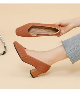 Detail view showing the ribbed knit texture and square toe of orange chunky heel pumps