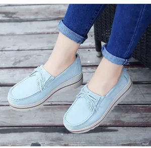 Primer plano de mocasines con plataforma azul claro con flecos y detalle de lazo