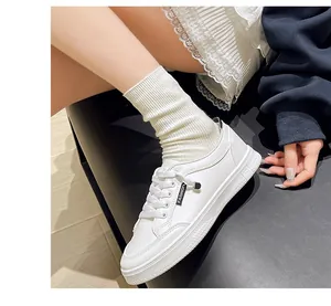 Dettaglio delle eleganti sneaker bianche rétro con lacci ed etichetta fashion
