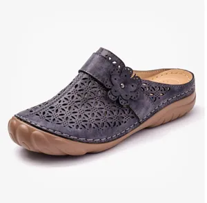Macro detail view of the floral laser-cut pattern on purple platform clogs for women