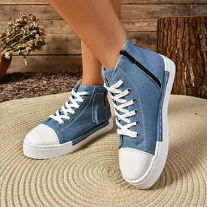 Detailweergave van blauwe denim hoge sneakers met witte veters en rits aan de zijkant