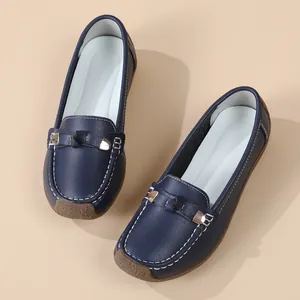 Detail of navy blue soft-soled loafers with metal buckle and contrast stitching