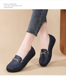 Stylish dark blue loafers for women with gold chain detail and soft comfortable flat soles.