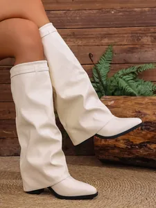 Detailed view of cream slouchy pointed-toe knee-high boots with chunky high heels