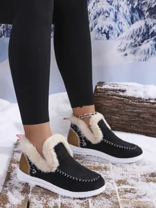 Macro view of women's warm winter shoes with soft white faux fur lining and black upper