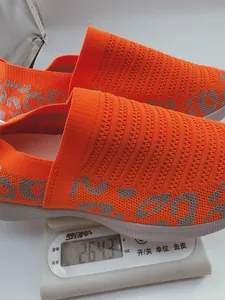 Lichtgewicht oranje instapsportschoen van mesh gewogen op een nauwkeurige weegschaal
