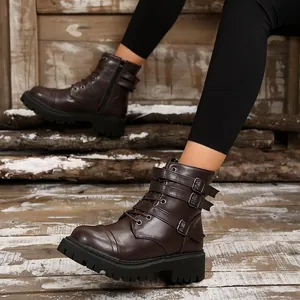 Detail of retro brown motorcycle boots featuring buckle straps and platform lug sole