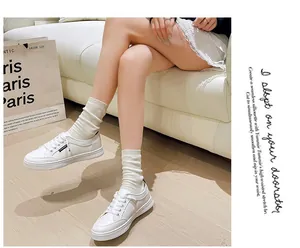 Eleganti sneaker bianche stringate con suola piatta e punta tonda classica in stile retrò