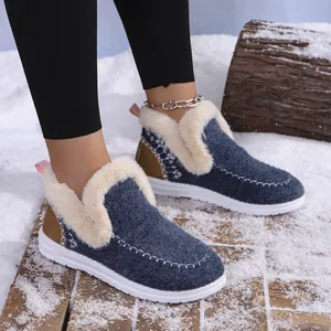 Close-up of blue warm snow boots with faux fur lining in a winter snowy scene