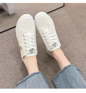 Vista superior de zapatillas de lona blancas para mujer con bordes deshilachados